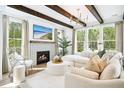 Bright living room with fireplace, wood beams, large windows, and stylish decor provides a comfortable and inviting space at 2048 Ten Point Dr, Charleston, SC 29492