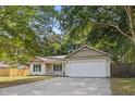 Inviting home featuring a two-car garage, a cozy front porch, and a well-maintained driveway at 210 Basswood Ave, Summerville, SC 29483