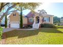 Lovely front lawn featuring a home with a charming entrance, two-car garage, and brick accents at 2206 Magnolia Meadows Dr, Mount Pleasant, SC 29464