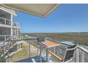Relaxing balcony with marsh views, complete with table and chairs, perfect for enjoying the natural surroundings at 221 E Mariners Cay # 221, Folly Beach, SC 29439