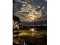 Night shot of the building exterior with a lovely view over the marsh and a large, bright moon shining through the clouds at 221 E Mariners Cay # 221, Folly Beach, SC 29439