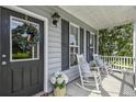 Inviting front porch with rocking chairs, floral arrangements, and seasonal wreath, offering a cozy welcome at 243 Old Savannah Dr, Goose Creek, SC 29445