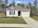 Charming single-story home featuring brick and siding accents, plus a well-maintained lawn and attached garage at 386 Spruce Ivy St, Moncks Corner, SC 29461