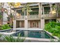 A stunning home featuring a pristine pool with outdoor living space, and lush tropical landscaping at 515 Claret Way, Kiawah Island, SC 29455