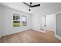 Bright, modern bedroom with a ceiling fan, light hardwood floors, and a view of the outdoors through the windows at 5180 Stono Plantation Dr, Hollywood, SC 29449