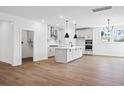 Open-concept kitchen featuring white cabinetry, an island with pendant lighting, and stainless steel appliances at 5180 Stono Plantation Dr, Hollywood, SC 29449