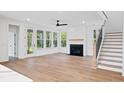 Spacious living room with a fireplace, staircase, and many windows that provide natural light and views of the outdoors at 5180 Stono Plantation Dr, Hollywood, SC 29449