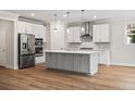 Modern kitchen with stainless steel appliances, gray cabinets, a center island, and hardwood floors at 5182 Stono Plantation Rd Dr, Hollywood, SC 29449