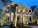 Charming two-story home adorned with holiday decorations and illuminated landscaping at twilight at 525 Scholar Way, Summerville, SC 29486