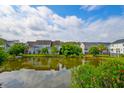 Lake view from backyard showing the well-maintained lawn and lush landscaping at 543 Mclernon Trce, Johns Island, SC 29455