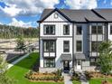 Close-up of new townhome with black framed windows, brick accents, and fresh landscaping at 562 Scholar Way, Summerville, SC 29486