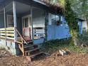 Modest blue house with a small porch and weathered wooden steps, surrounded by leaves at 7112 Old Jacksonboro Rd, Ravenel, SC 29470