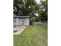 Exterior shot of garage with red door and chainlink fence on a grassy area at 715 Yew St, Charleston, SC 29407