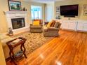 Inviting living room featuring hardwood floors, a brick fireplace with white mantle, and comfortable seating at 946 Law Ln, Mount Pleasant, SC 29464