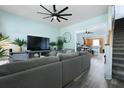 Comfortable living room with a large gray sofa, ceiling fan, and view to the kitchen at 101 Barberry St, Summerville, SC 29483