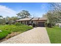 Brick driveway leads to an attached garage in a well-kept landscaped yard with mature trees at 1039 Grand Concourse St, Charleston, SC 29412