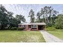 Charming brick house with an attached carport, nicely landscaped lawn and an inviting facade at 105 Dandridge Rd, Walterboro, SC 29488