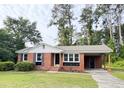 Charming brick house with an attached carport, nicely landscaped lawn and an inviting facade at 105 Dandridge Rd, Walterboro, SC 29488