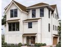 Elegant three-story home boasts a mix of white siding and brick, dark windows, and a well-manicured front garden at 13 Trumbo St, Charleston, SC 29401