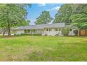 Charming single-story brick home with a well-maintained lawn and mature trees, offering classic curb appeal at 1350 Mosstree Rd, North Charleston, SC 29405