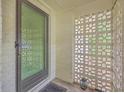 Close-up of the home's entrance, highlighting the unique breezeblock wall and classic storm door at 1350 Mosstree Rd, North Charleston, SC 29405