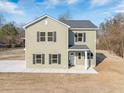 A charming new construction home displaying a neutral siding with black shutters and front porch at 1738 Us-52, Moncks Corner, SC 29461