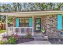 Inviting front porch with white railings, colorful shutters, and brick facade, perfect for enjoying the outdoors at 202 Pamela Ln, Summerville, SC 29483