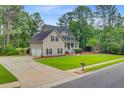 Well-maintained home with a two-car garage, a large lawn, and mature trees at 204 Bellerive Ln, Summerville, SC 29483