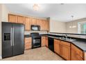 Efficient kitchen featuring wood cabinets, black appliances, and eat-in bar area at 2244 Ashley Crossing Dr # 534, Charleston, SC 29414