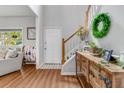 Open foyer featuring staircase with greenery, leading to living room with large window and wood floors at 261 Mossy Oak Way, Mount Pleasant, SC 29464