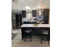Modern kitchen with stainless steel appliances, island with seating, and sleek black cabinetry at 307 Glen St, Summerville, SC 29483