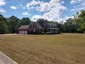 Spacious home with a three-car garage, surrounded by a large lawn and mature trees at 351 Duncan Chapel Rd, Harleyville, SC 29448