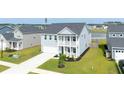 Charming two-story home featuring a light blue facade, a second story balcony, and a well manicured lawn at 447 Navona Dr, Summerville, SC 29486