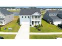 Charming two-story home featuring a light blue facade, a second story balcony, and a well manicured lawn at 447 Navona Dr, Summerville, SC 29486