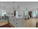 Open-concept kitchen with island, breakfast bar, stainless appliances, and views into the living and dining areas at 48 Aiken St, Charleston, SC 29403