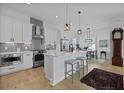 Modern kitchen with white cabinets, island, stainless steel appliances, and an adjacent dining area at 48 Aiken St, Charleston, SC 29403