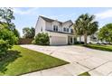 Spacious driveway leading to a two-car garage, complemented by lush green landscaping and a fenced yard at 5257 Mulholland Dr, Summerville, SC 29485