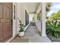 Inviting front porch with white pillars, a cozy space for relaxing, and a beautifully landscaped entrance at 5257 Mulholland Dr, Summerville, SC 29485