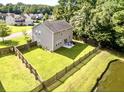 Aerial view of a backyard with a well maintained lawn, patio seating, and privacy fence at 610 Knowledge Dr, Ladson, SC 29456