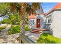 Charming home featuring a turret entrance with a red door, complemented by a mature palm tree and tidy landscaping at 7 Wesley Dr, Charleston, SC 29407