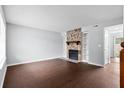 Open living room featuring a stone fireplace with built-in shelves and wood flooring at 7813 Sandida Ct, North Charleston, SC 29418