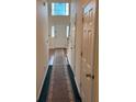 Hallway with decorative carpet runner and view to entry door with sidelights at 8522 Long Meadow Dr, Charleston, SC 29420