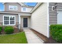Inviting front entrance with covered porch, manicured bushes, and concrete walkway at 9711 Tackle St, Ladson, SC 29456