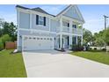 Charming two-story home featuring a light blue facade, inviting front porch, and well-manicured lawn at 1004 Saltwater Cir, Johns Island, SC 29455
