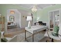 Bright office with stylish desk, piano, chandelier, and calming sage green walls at 1004 Saltwater Cir, Johns Island, SC 29455