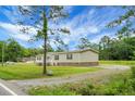 Charming single-story home surrounded by lush greenery, boasting a cozy front porch and well-maintained lawn at 1051 Cooper Store Rd, Moncks Corner, SC 29461