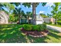 Charming single-story home with a well-manicured lawn, palm trees, and an attached two-car garage at 1231 Wild Olive Dr, Mount Pleasant, SC 29464