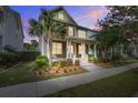 Charming two-story home featuring a welcoming front porch, manicured landscaping, and a beautiful palm tree at 1363 Rivella Dr, Mount Pleasant, SC 29464