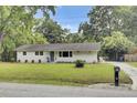 Charming single-story home featuring a landscaped lawn, a welcoming front door with a wreath, and light gray siding at 1515 Mulberry St, Charleston, SC 29407