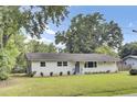 Charming single-story home featuring a landscaped lawn, a welcoming front door with a wreath, and light gray siding at 1515 Mulberry St, Charleston, SC 29407